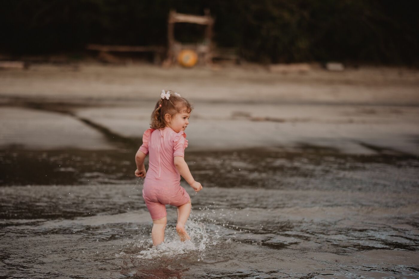 A toddler splashing through a puddle